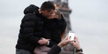 A couple of tourists kiss as they pose with the Eiffel Tower in background at the Trocadero esplanade, in Paris on December 31, 2019\u002E (Photo by Zakaria ABDELKAFI / AFP) paris francia  turismo en la torre eiffel pareja beso besandose turistas esplanada trocadero