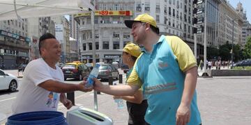 AME5275\u002E BUENOS AIRES (ARGENTINA), 29/01/2018\u002E- Ciudadanos reciben botellas con agua para refrescarse debido a la ola de calor, este martes, en Buenos Aires (Argentina)\u002E De acuerdo con el Servicio Meteorológico Nacional se esperan temperaturas máximas de 37 grados y humedad del 60 % en Buenos Aires\u002E EFE/ Pablo Ramón buenos aires ola de calor en la ciudad altas temperaturas verano calor gente caminando por la calle calles