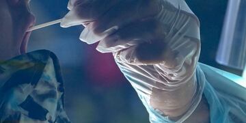 A healthcare worker administers a coronavirus test for a motorist at a drive-through Covid-19 testing center at M\u002ET\u002EO\u002E Shahmaghsoudi School of Islamic Sufism on September 29, 2020 in Los Angeles, California\u002E (Photo by Robyn Beck / AFP)