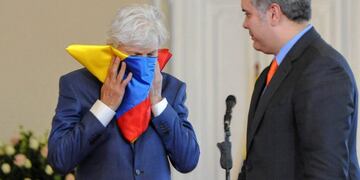 Handout picture released by the Colombian Presidency press office showing the former coach of the national football team, Argentine Jose Nestor Pekerman (L) kissing the Colombian national flag after it was given to him by Colombian President Ivan Duque in gratitude for his task at the helm of the Colombian squad, at the Casa Narino palace in Bogota, on September 17, 2018\u002E (Photo by HO / Colombian Presidency / AFP) / RESTRICTED TO EDITORIAL USE - MANDATORY CREDIT \