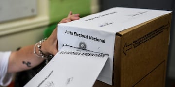 27 October 2019, Argentina, Buenos Aires: A woman casts her ballot into a ballots box at a polling station during the Argentine general election\u002E Photo: Fernando Gens/dpa  URNA  URNAS  VOTACION