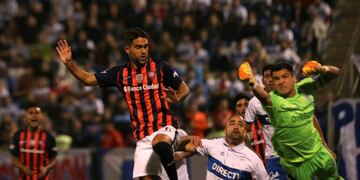 Matias Caruzzo of Argentina's San Lorenzo, left, fights for the ball with goalkeeper Cristopher Toselli of Chile's Universidad Catolica during a Copa Libertadores soccer match in Santiago, Chile, Wednesday, April 12, 2017. (AP Photo/Esteban Felix)