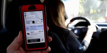 FILE PHOTO: A cell phone with the Uber transport technology app, with the destination and its cost to the international airport, is seen inside a car with an Uber driver, in Santiago, Chile, March 15, 2019\u002E REUTERS/Rodrigo Garrido/File Photo