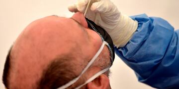 A health worker takes a swab sample from a man being tested for COVID-19 coronavirus, in Bogota, on July 8, 2020\u002E (Photo by Raul ARBOLEDA / AFP)  hisopado