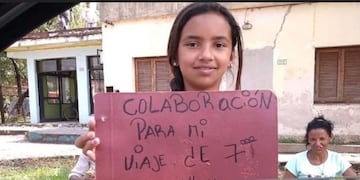 Daiana y su cartel en el que pide ayuda para su viaje de estudios que paga vendiendo limones en la calle\u002E (Clarín)