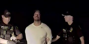 In this image taken from video golfer Tiger Woods stands between two police officers in Jupiter Florida Monday May 29,2017. Police in the US state of Florida have released video of professional golfer Tiger Woods' recent arrest. Jupiter Police released the dash-cam footage of the incident late on Wednesday May 31, 2017. Officers on patrol early on Monday noticed a Mercedes pulled awkwardly to the side of the road with the engine running, the brake lights on and a right indicator blinking. (Jupiter Police Department/via AP)