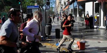 El periodista Julio Bazán se escapa luego de ser brutalmente agredido en la zona de la 9 de Julio\u002E (Foto: Marcelo Carroll)