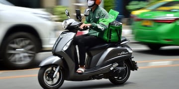This photo taken on May 4, 2020 shows a Grab Food delivery driver in Bangkok, as the volume of online food orders have soared since the stay home restrictions were put in place to fight the COVID-19 coronavirus\u002E - Gourmet take-out delivered by a butler in a black sedan -- Thailand's super-rich have not forgone luxury during a pandemic which has locked the country down, crushed the economy and left millions unemployed\u002E (Photo by Lillian SUWANRUMPHA / AFP) / TO GO WITH Health-virus-Thailand-social,FOCUS by Dene-Hern Chen