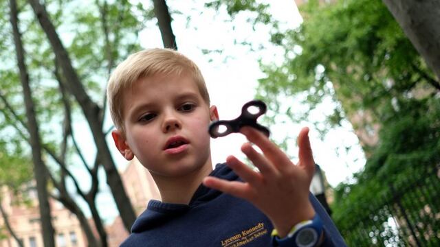 Ten-year-old Louis Wuestenberg plays with a fidget spinner in a park in New York on May 23, 2017. nIt was supposed to calm nerves, relieve stress and improve concentration but the new-anti fidget toy spreading fast through US and European schools is whipping up anger among teachers on both sides of the Atlantic. Just months after the