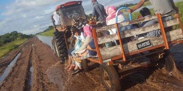 Un tractor lleva evacuados por los caminos destruidos a causa de las lluvias\u002E