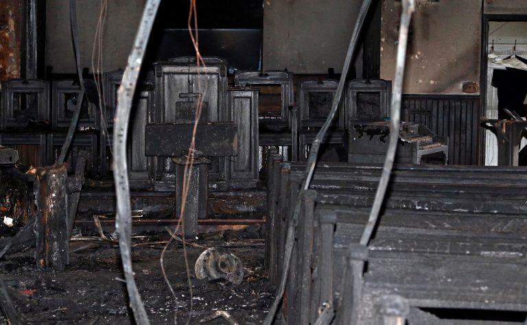 Cables hang from the ceiling in the fire damaged Hopewell M.B. Baptist Church in Greenville, Miss., Wednesday, Nov. 2, 2016. "Vote Trump" was spray-painted on an outside wall of the black member church. Fire Chief Ruben Brown tells The Associated Press that firefighters found flames and smoke pouring from the sanctuary of the church just after 9 p.m. Tuesday. (AP Photo/Rogelio V. Solis)