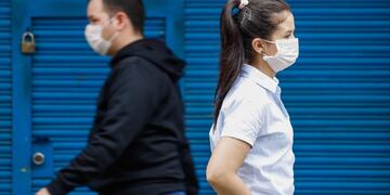 AME2206\u002E ASUNCIÓN (PARAGUAY), 13/04/2020\u002E- Transeúntes caminan con tapabocas este lunes, en Asunción (Paraguay)\u002E El ministro del Interior, Euclides Acevedo, y Federico González, ministro asesor, hablaron, este lunes en conferencia de prensa, sobre la continuidad de la cuarentena sanitaria, el uso obligatorio de tapabocas y sobre el ingreso de personas a albergues transitorios en la frontera de Paraguay con Brasil\u002E EFE/ Nathalia Aguilar