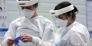 BOWIE, MARYLAND - MAY 29: Clinicians put on personal protective equipment at a drive-thru coronavirus testing location at Six Flags America May 29, 2020 in Bowie, Maryland\u002E The state of Maryland opened the new COVID-19 testing site to offer residents who want to receive a free test with no doctors order or appointment is required\u002E Alex Wong/Getty Images/AFP\n== FOR NEWSPAPERS, INTERNET, TELCOS & TELEVISION USE ONLY ==