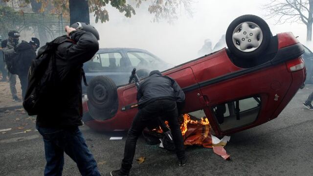 Manifestantes enmascarados volcan un automóvil mientras chocan con la policía antidisturbios durante la manifestación en París , Francia, 16 de noviembre de 2019\u002E Crédito: EFE / EPA / YOAN VALAT\u002E
