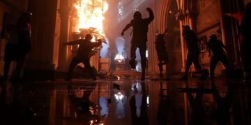Protesters storm the San Francisco de Borja church, that belongs to Carabineros, Chile's national police force, on the one-year anniversary of the start of anti-government mass protests over inequality in Santiago, Chile, Sunday, Oct\u002E 18, 2020\u002E (AP Photo/Esteban Felix)