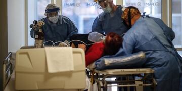 Personal médico traslada en camilla a una paciente covid-19 en el Hospital del Bicentenario de Esteban Echeverria. (Foto: EFE/ Juan Ignacio Roncoroni)
