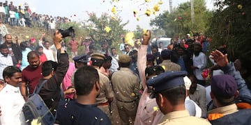People throw flower petals on the Indian policemen guarding the area where rape accused were shot, in Shadnagar some 50 kilometers or 31 miles from Hyderabad, India, Friday, Dec\u002E 6, 2019\u002E An Indian police official says four men accused of raping and killing a woman in southern India have been fatally shot by police\u002E (AP Photo/Mahesh Kumar A\u002E)
