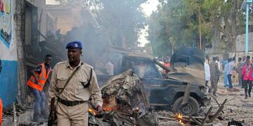 Somali soldier walk near wreckage of vehicles after a car bomb was detonated in Mogadishu, Somalia Saturday, Oct 28, 2017\u002E A suicide car bomb exploded outside a popular hotel in Somalia's capital on Saturday, killing at least 10 people and wounding more than 11, while gunfire could be heard inside, police said\u002E A second blast was heard in the area minutes later\u002E (AP Photo/Farah Abdi Warsameh)