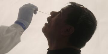A healthcare worker wearing personal protective equipment (PPE) takes a swab sample from a man for the coronavirus disease (COVID-19) test at the Jardin de las Artes Graficas Park in Mexico City, Mexico October 22, 2020\u002E REUTERS/Henry Romero