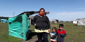 Yennifer Molina, 23, poses for a picture next to her children Francisco, 3, and Leonor, 2, at the patch of land she occupied, amid the spread of the coronavirus disease (COVID-19) in Guernica, on the outskirts of Buenos Aires, Argentina September 16, 2020\u002E REUTERS/Agustin Marcarian
