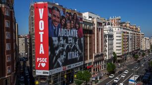 Un gigantesco cartel electoral muestra al presidente del gobierno español y candidato del Partido Socialista, Pedro Sánchez, arriba, y al líder del conservador Partido Popular, Albert Núñez Feijóo, y del grupo de ultraderecha Vox, Santiago Abascal.  (AP Foto / Manu Fernández)