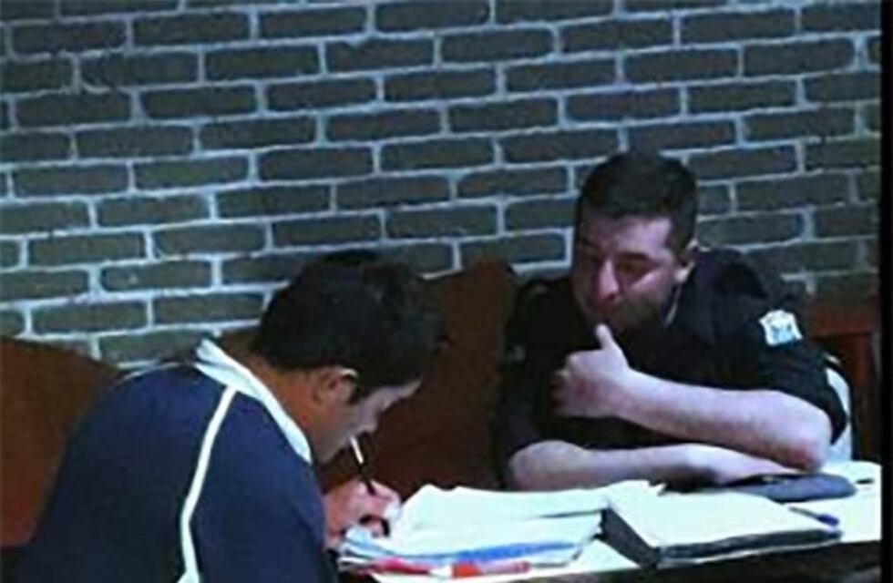 La conmovedora foto del policía que ayuda a leer y a escribir en un refugio