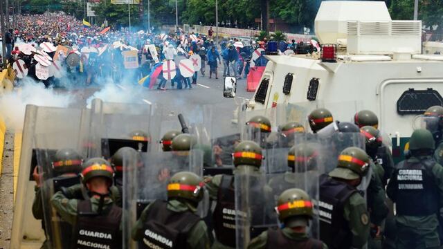Riot police and demonstrators clash during a protest against Venezuelan President Nicolas Maduro, in Caracas on May 3, 2017.nVenezuela's angry opposition rallied Wednesday vowing huge street protests against President Nicolas Maduro's plan to rewrite the constitution and accusing him of dodging elections to cling to power despite deadly unrest. / AFP PHOTO / RONALDO SCHEMIDT