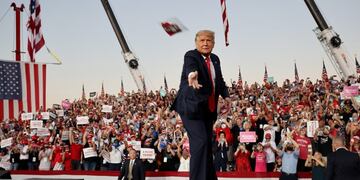 FILE PHOTO: U\u002ES\u002E President Donald Trump tosses face masks to the crowd as he takes the stage for a campaign rally, his first since being treated for the coronavirus disease (COVID-19), at Orlando Sanford International Airport in Sanford, Florida, U\u002ES\u002E, October 12, 2020\u002E REUTERS/Jonathan Ernst/File Photo