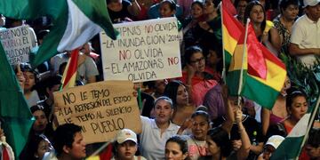 People attend a rally summoned by the National Commitee in Defense of Democracy (CONADE) with signs reading \