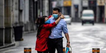 Guangzhou (China), 14/02/2020\u002E- A couple wearing protective masks walks on the street on Valentine's Day in Guangzhou, China, 14 February 2020\u002E Many flower markets, restaurants, cinemas and others stores remained closed due to the coronavirus crisis\u002E The outbreak, which originated in the Chinese city of Wuhan, has so far killed at least 1,383 people with over 64,000 infected worldwide, mostly in China\u002E (Cine) EFE/EPA/ALEX PLAVEVSKI