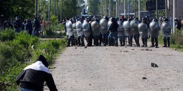 A man grabs stones from the ground as he confronts police officers carrying out an eviction at a squatters camp in Guernica, on the outskirts of Buenos Aires, Argentina October 29, 2020\u002E REUTERS/Agustin Marcarian