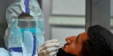 A health worker takes a swab sample from a man to test for the COVID-19 coronavirus at a testing centre in Srinagar on July 17, 2020\u002E - EU leaders met face to face on July 17 to try to rescue Europe's economy from the ravages of the coronavirus pandemic, as India became the third country to record one million cases, joining Brazil and the United States\u002E (Photo by TAUSEEF MUSTAFA / AFP)