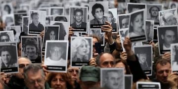 People hold images of the victims of the 1994 bombing attack on the Argentine Israeli Mutual Association (AMIA) community centre, marking the 25th anniversary of the attack, in Buenos Aires, Argentina, July 18, 2019\u002E REUTERS/Agustin Marcarian