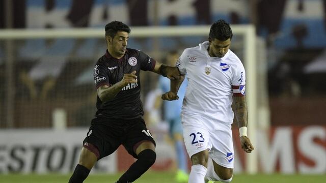 Uruguay's Nacional defender Diego Polenta (L) vies for the ball with Argentina's Lanus midfielder Roman Martinez during the Copa Libertadores 2017 group first leg football match at Lanus stadium in Lanus, Buenos Aires, Argentina, on March 9, 2017. / AFP P