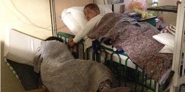 Thiago y su mamá, en la sala de oncología del Hospital de Niños dormidos y tomaditos de la mano\u002E (Facebook Juan Pablo Rodríguez)