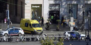 Policemen and medical staff members stand in the entrance of a mall after a van ploughed into the crowd, killing two persons and injuring several others on the Rambla in Barcelona on August 17, 2017\u002E\nA driver deliberately rammed a van into a crowd on Barcelona's most popular street on August 17, 2017 killing at least two people before fleeing to a nearby bar, police said\u002E \nOfficers in Spain's second-largest city said the ramming on Las Ramblas was a \