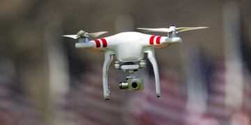 ARCHIVOu00a0- Imagen de un drone en Los Angeles, California (EEUU), el 10/09/2015, sobre un trasfondo de banderas estadounidenses. Este 21/06/2016 autoridades de aviaciu00f3n de Estados Unidos anunciaron que se autorizaru00e1 el vuelo de pequeu00f1os drones comerciales.