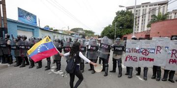 Una manifestante sostiene una bandera de Venezuela y baila frente a la policu00eda durante una protesta opositora el 01/06/2017 en Valencia, Venezuela. foto: Juan Carlos Hernandez/ZUMA Wire/dpa