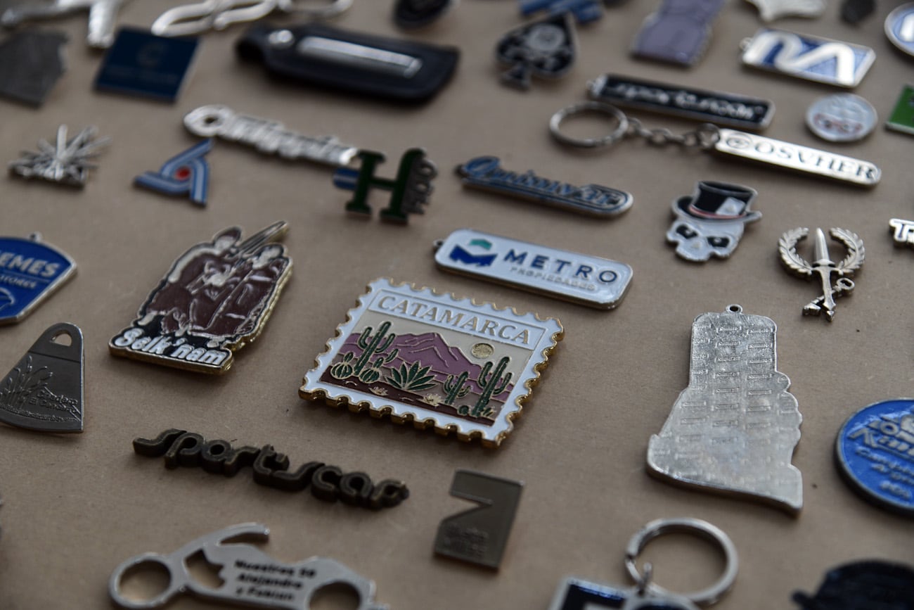 Algunos de los pines y llaveros que ha realizado la empresa. (Ramiro Pereyra / La Voz)