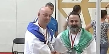 Maksim Svirsky y Mustafa Rajaei, atletas israelí e iraní respectivamente, dándose la mano luego de quedar tercero y segundo en una competencia de levantamiento de pesas en Polonia. Foto: Los Andes.