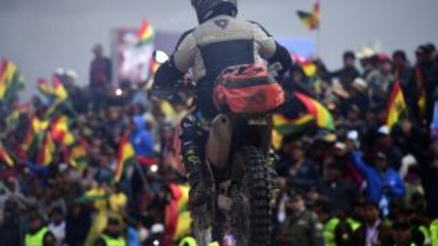 Bolivians waves national flags as competitors arrive at the end of Stage 5 of the 2017 Dakar Rally between Tupiza and Oruro in Bolivia, on January 6, 2017. / AFP PHOTO / Franck FIFE