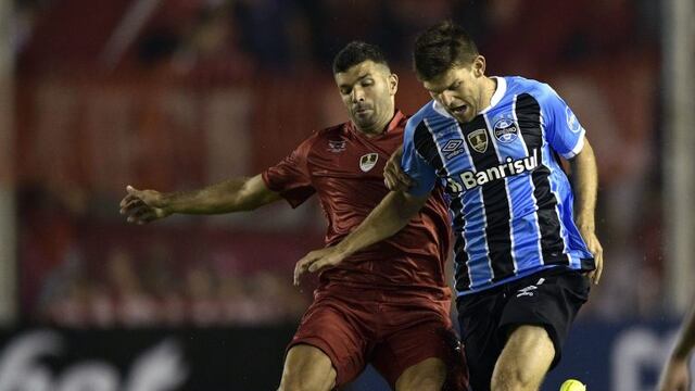Brazil's Gremio defender Walter Kannemann (R) vies for the ball with Argentina's Independiente forward Emmanuel Gigliotti during their Recopa Sudamericana 2018 first leg final football match at Libertadores de America stadium in Avellaneda, Buenos Aires, on February 14, 2018\u002E / AFP PHOTO / Juan MABROMATA