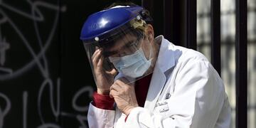 A doctor speaks on a mobile phone as health workers demand better working conditions and pay homage to nurse Grover Licona, who died from COVID-19, outside the Carlos G\u002E Durand hospital in Buenos Aires, on August 18, 2020, amid the new coronavirus pandemic\u002E (Photo by JUAN MABROMATA / AFP)