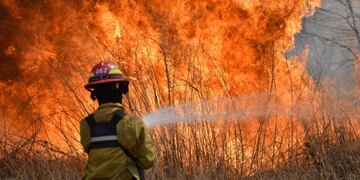 23 September 2020, Argentina, Cordoba: A firefighter douses flames of a wildfire near the Argentine National Observatory\u002E Photo: Irma Montiel/telam/dpa