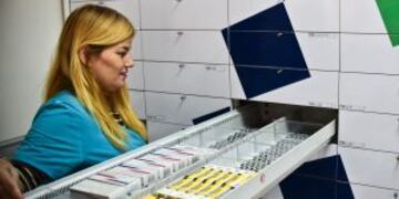 A worker of a pharmacy opens a half empty empty drewer in Caracas on May 30, 2016.rn The shortage of medicines in Venezuela exceeds 85%, revealed the president of the harmaceutical federation of Venezuela, Freddy Ceballos. / AFP PHOTO / RONALDO SCHEMIDT v