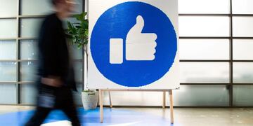 (FILES) In this file photo taken on October 23, 2019 a Facebook employee walks by a sign displaying the \