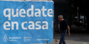 A man walks past a street sign that reads \