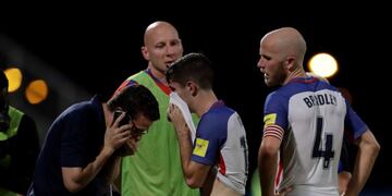 United States' Christian Pulisic, center, and his teammate United States' Michael Bradley, right, walk on the pitch after losing 2-1 against Trinidad and Tobago during a 2018 World Cup qualifying soccer match in Couva, Trinidad, Tuesday, Oct\u002E 10, 2017\u002E (AP Photo/Rebecca Blackwell)