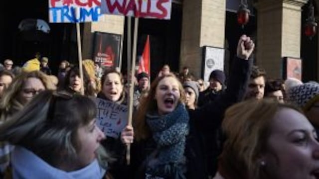A woman holds a placard reading