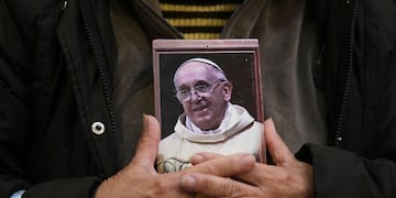 Un fiel sostiene un retrato del difunto papa Francisco en la Basílica de San José de Flores, donde rezaba en su juventud, tras el anuncio del Vaticano de su fallecimiento en Buenos Aires, Argentina, el lunes 21 de abril de 2025. (Foto AP/Gustavo Garello)